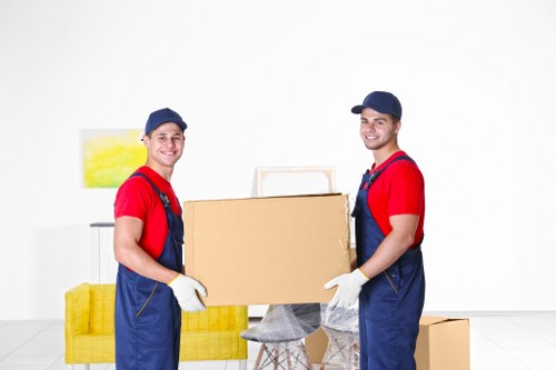 Piano removals team handling an upright piano in Camden